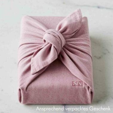 Geschenk in rosa Stoff eingewickelt.